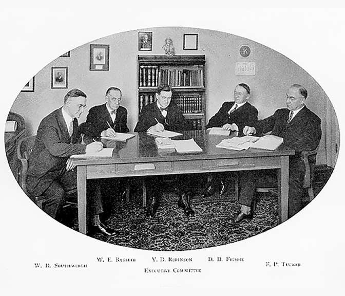 Black and white photo of NYCM Insurance V. D. Robinson Executive Committee meeting around a wooden table.